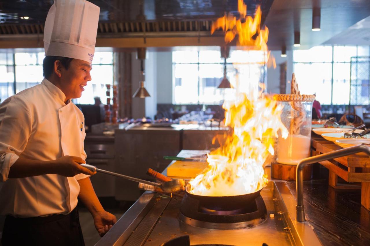 Novotel Chennai Chamiers Road Exterior foto A chef cooking with a wok